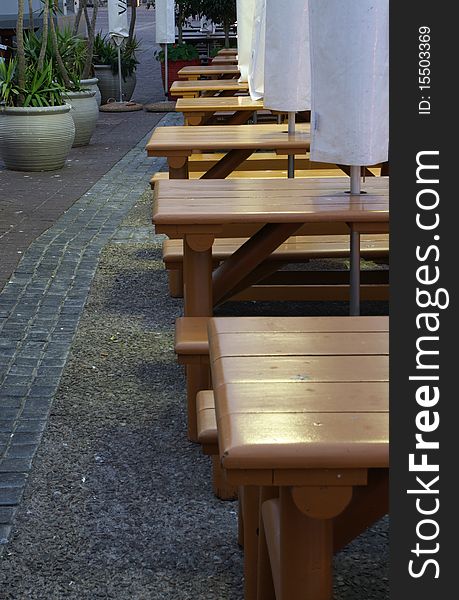 Empty wooden benches of a outside cafe.