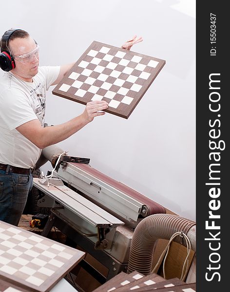 Carpenter working on an electric buzz saw cutting some boards