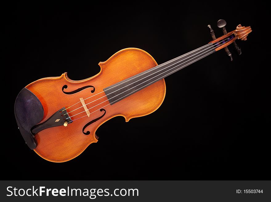 A violin viola isolated against a black background in the horizontal format. A violin viola isolated against a black background in the horizontal format.