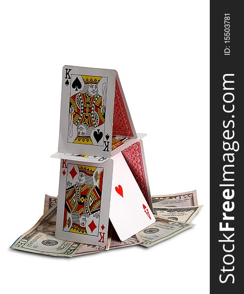 House of cards standing on dollar bills  isolated on white background; symbol of economic crisis and housing market. House of cards standing on dollar bills  isolated on white background; symbol of economic crisis and housing market