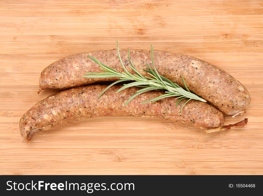 Traditional sausages on a wooden background decorated with rosemary twig
