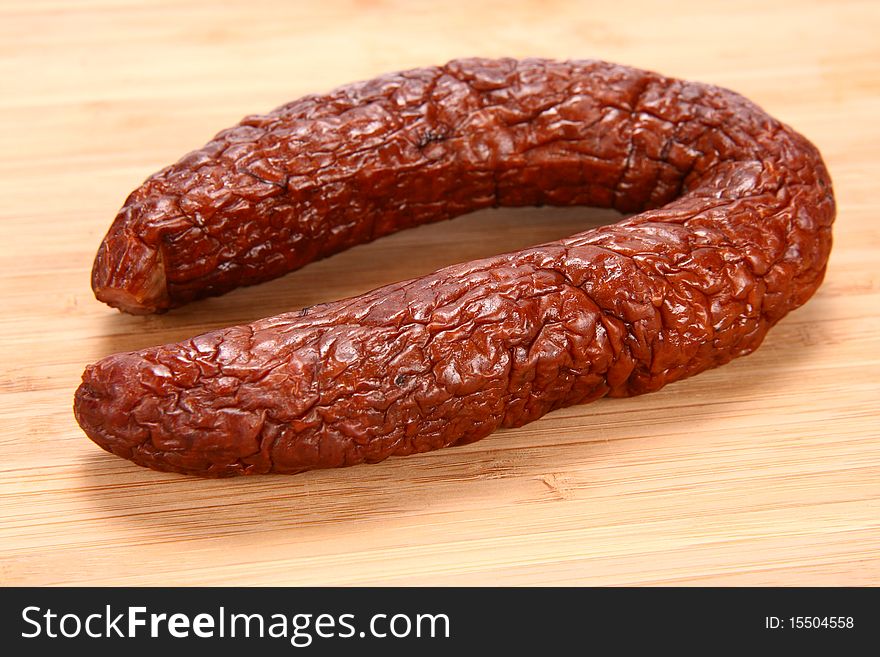 Smoked sausage on a wooden background