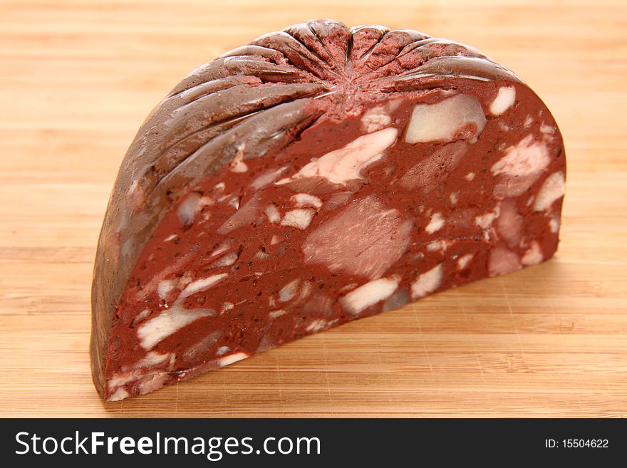 Traditional sausage: Headcheese on wooden background