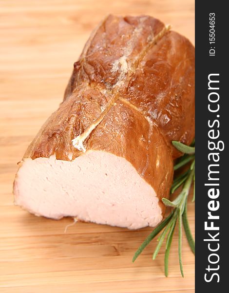 Piece of sirloin decorated with rosemary on a wooden background