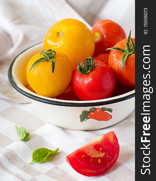 Colorful  tomatoes in bowl on kitchen table