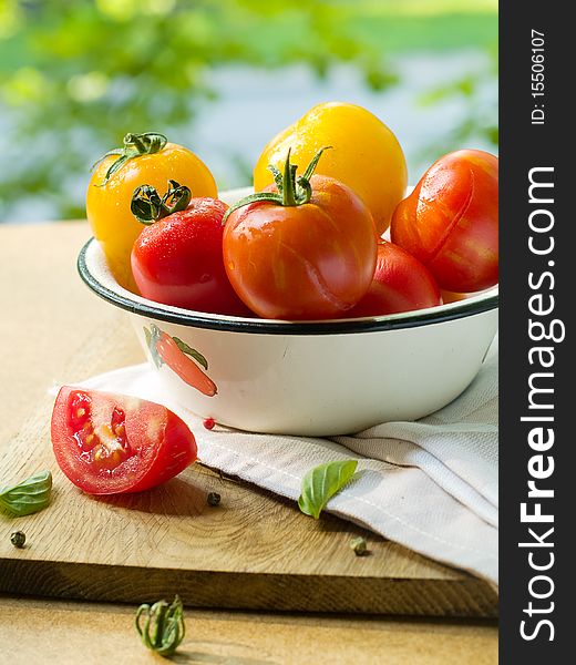 Colorful  tomatoes in bowl on kitchen table