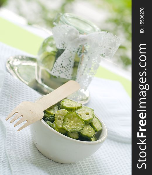 Fresh salted cucumber in bowl on kitchen towel