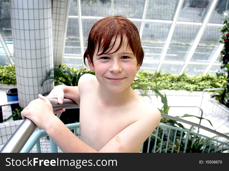 Young boy with red hair gets out of the pool