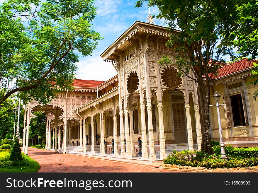 The Abhisek Dusit Throne Hall, a single story ornate building with beautifully carved floral motifs on panels adorning the gables and eaves.