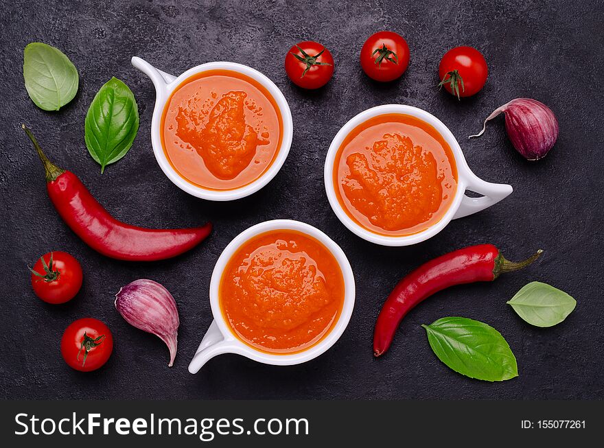 Homemade vegetable red sauce in ceramic bowl on black slate background. Selective focus