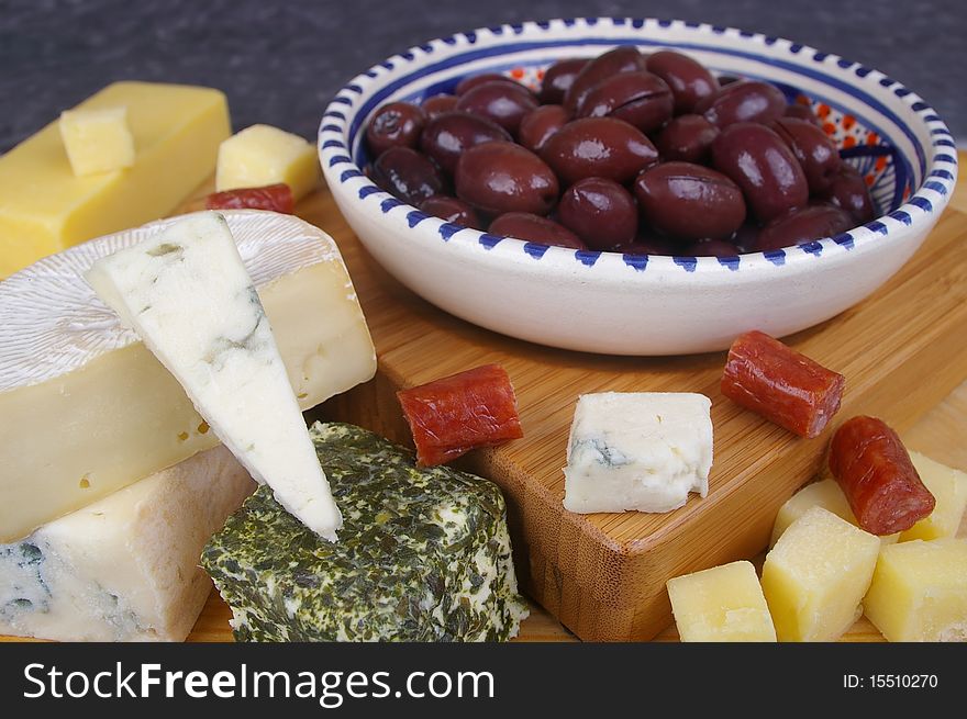 Cheese antipasto varieties on board with kalamata olives. Cheese antipasto varieties on board with kalamata olives