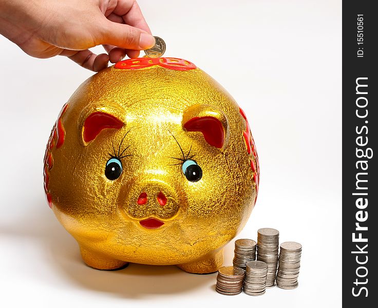 Drop coin in gold piggy bank for savings