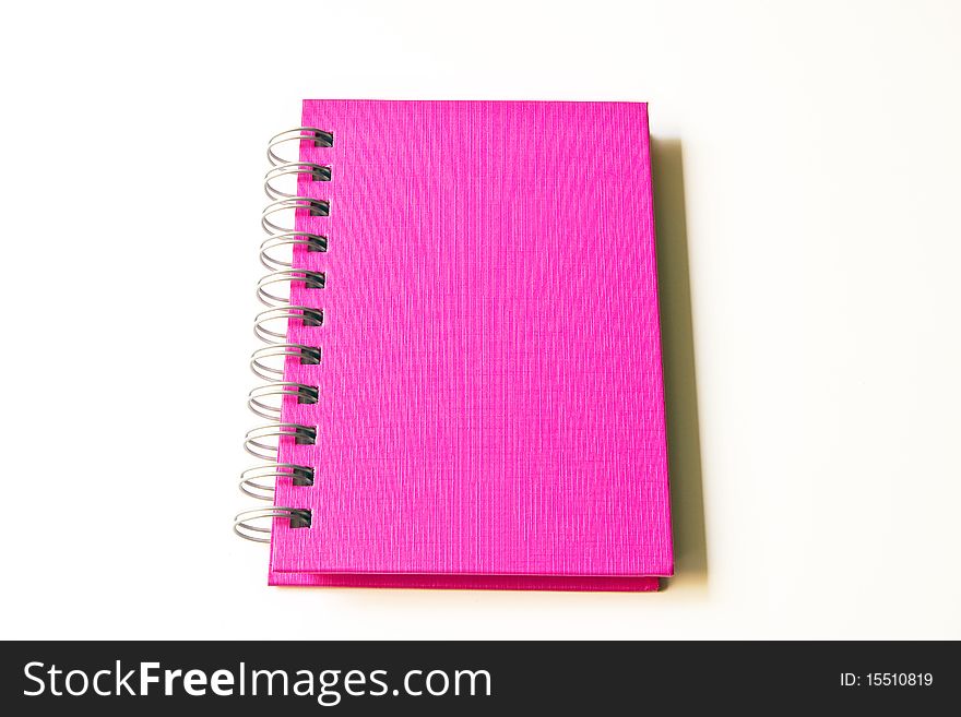 The blank pink notebook isolated on the white background