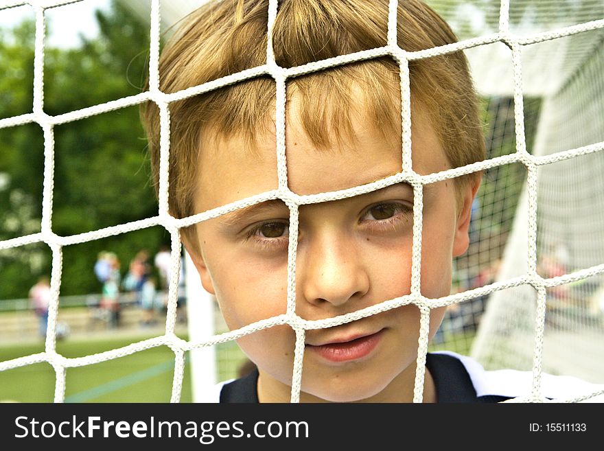 Young soccer player behind the net