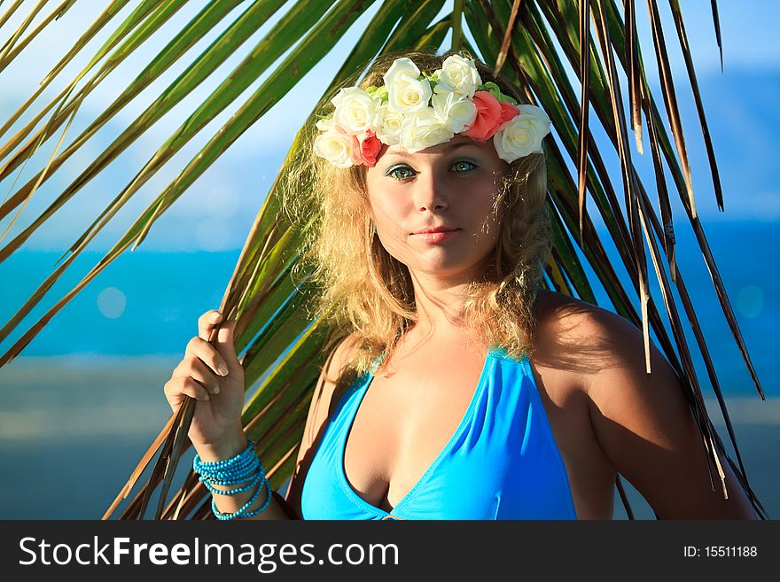 Woman in flower diadem on the beach