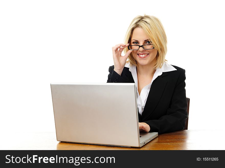 Happy young successful woman sitting at desk with laptop isolated on white. Happy young successful woman sitting at desk with laptop isolated on white