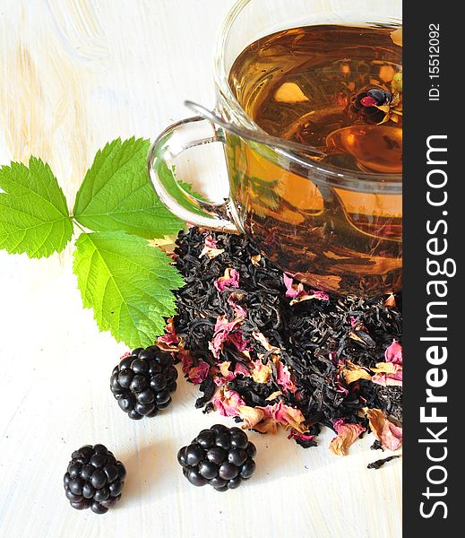 Tea is brewed in a cup, near the cup of berry and dry tea. Tea is brewed in a cup, near the cup of berry and dry tea