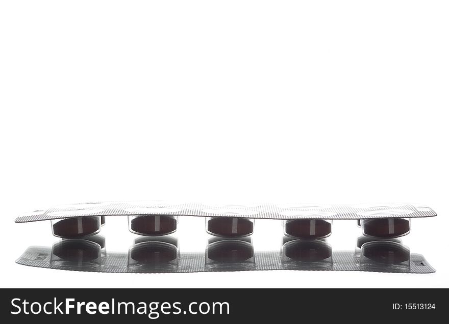 Closeup Of A Pack Of Brown Pills Isolated On White