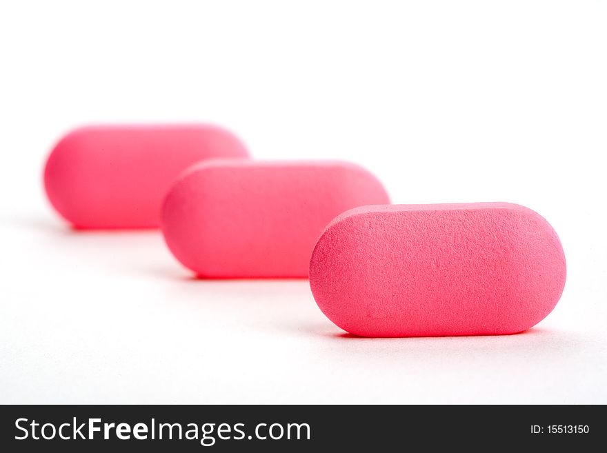 Extreme Close-up Of Pink Pills Isolated On White