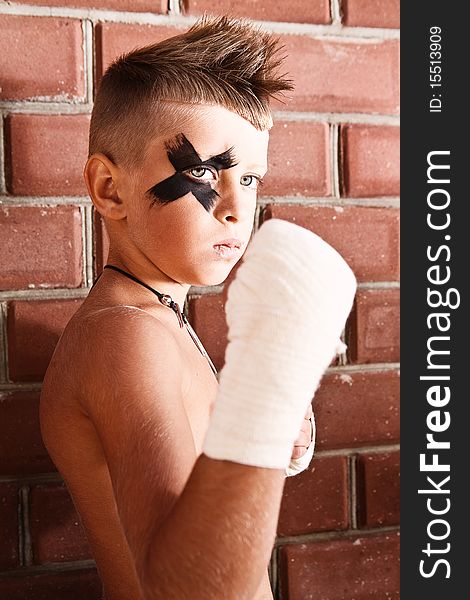 Little kick-boxing boy on the grange background. Little kick-boxing boy on the grange background