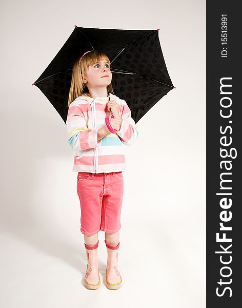 A vertical image, lovely little blonde blue eyed girl,dressed in pink rainwear,holding umbrella,looking upwards, isolated against a plain background. A vertical image, lovely little blonde blue eyed girl,dressed in pink rainwear,holding umbrella,looking upwards, isolated against a plain background