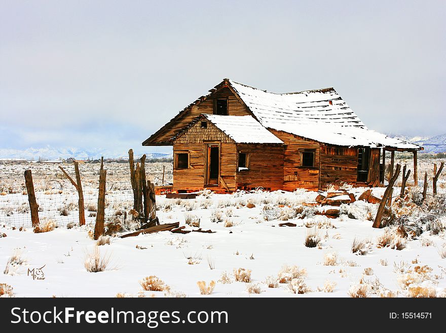 Abandoned homestead on prairie in winter snows