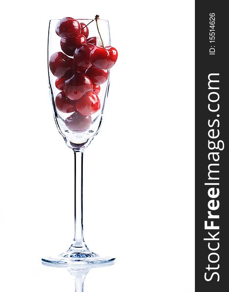 Cherries in a champagne glass on white background