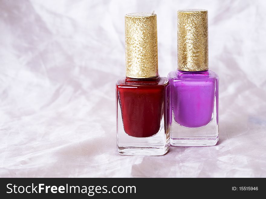 Two nail polish bottles over white background