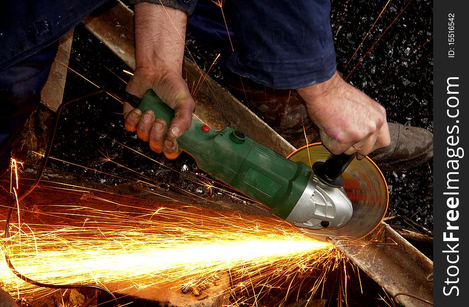 A worker is cutting metal with a circular saw. orange sparks. A worker is cutting metal with a circular saw. orange sparks.