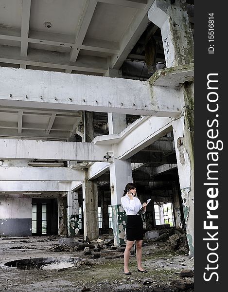 successful business person dicussing on cell phone about demolished building for real estate industry. successful business person dicussing on cell phone about demolished building for real estate industry