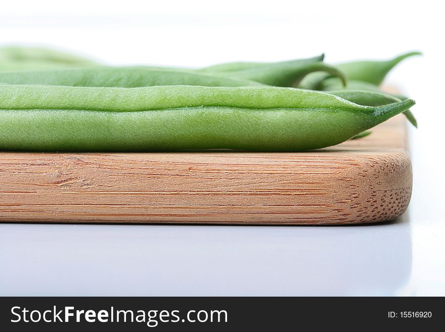 Vegetable kidney bean beans against on a kitchen board.