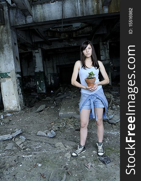Young woman posing with pot in demolished building. Young woman posing with pot in demolished building