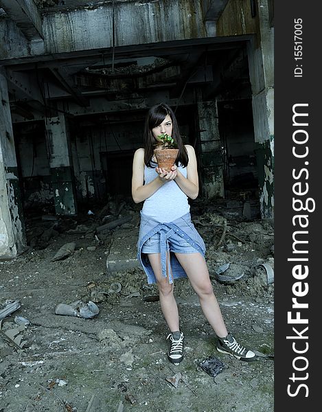 Young woman posing with pot in demolished building. Young woman posing with pot in demolished building