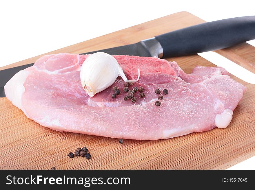 Piece of crude meat with black pepper on a kitchen board. Piece of crude meat with black pepper on a kitchen board.