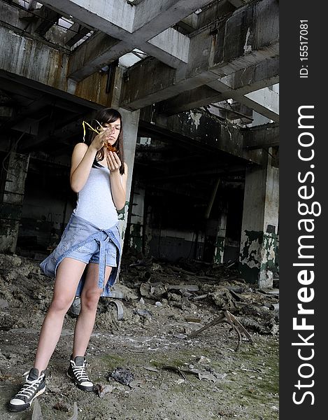 Caucasian young woman studying plant in devastated building. Caucasian young woman studying plant in devastated building