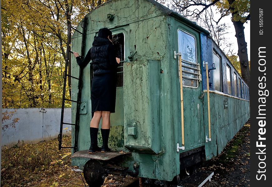 Woman strands on back side of old squalid rail coach. Woman strands on back side of old squalid rail coach