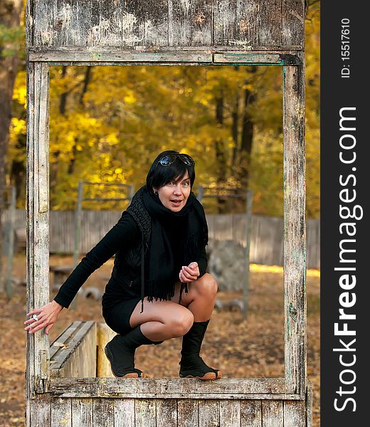 Outdoor portrait of young woman in dirty wooden frame. Outdoor portrait of young woman in dirty wooden frame