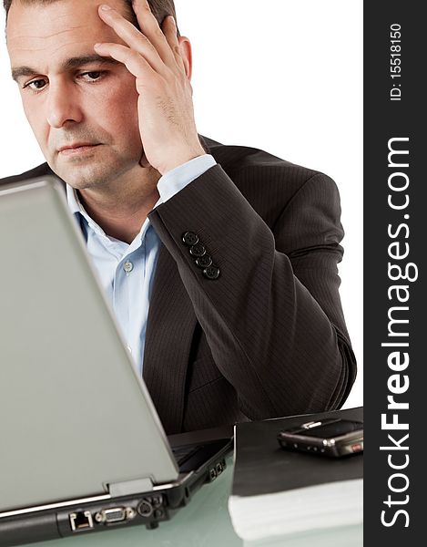 Businessman working on laptop, leaning hand on head thinking. Businessman working on laptop, leaning hand on head thinking