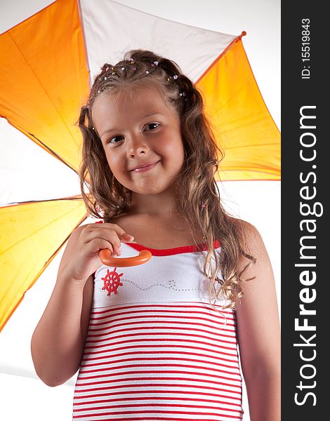 Little girl wearing summer dress and holding umbrella, studio shot