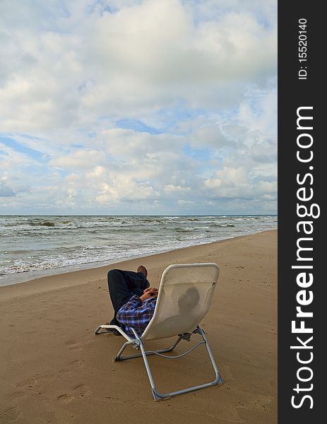 Man sitting in chair on the beach. Man sitting in chair on the beach.