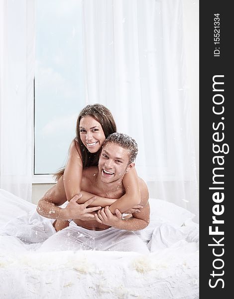 Young love couple in bed with feathers. Young love couple in bed with feathers