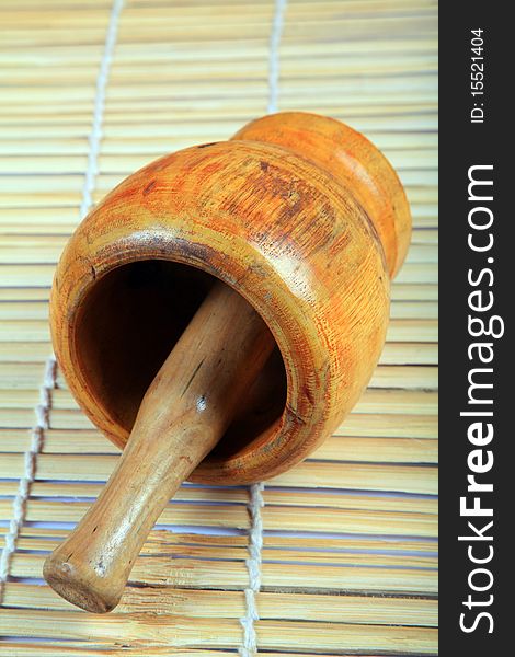 Wooden mortar and pestle with wooden background.