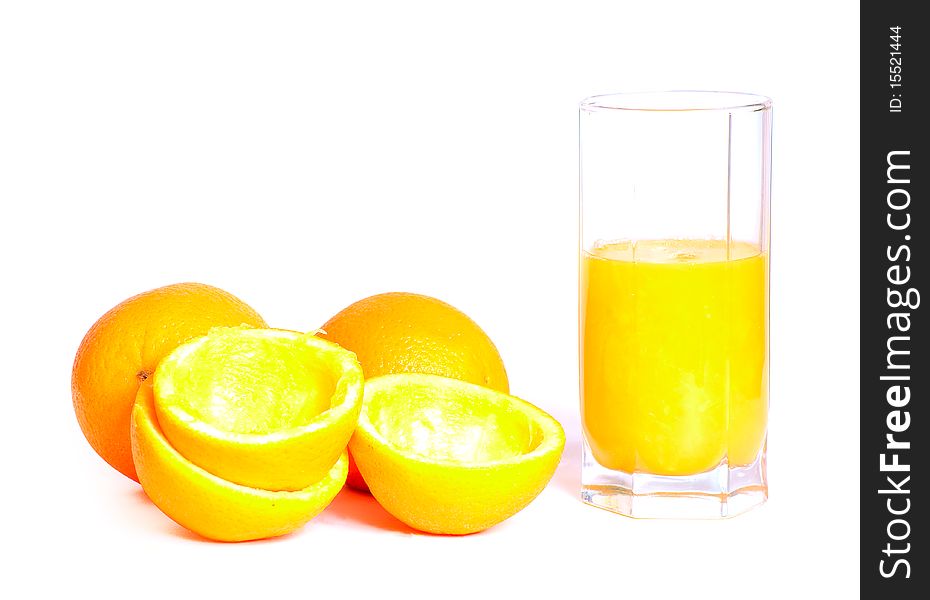 Glass of fresh orange juice with oranges lying nearby