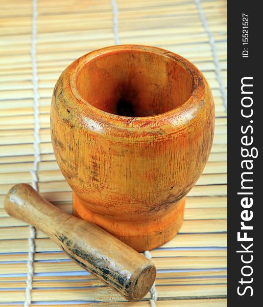 Wooden mortar and pestle with wooden background.