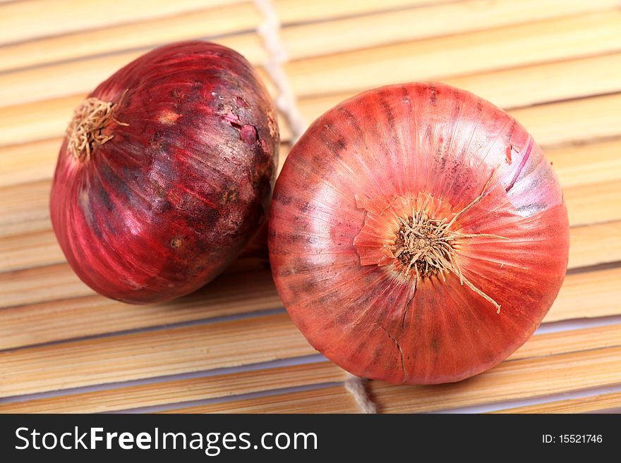 Two onions with wooden background.