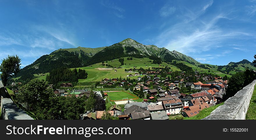 Panorama image taken above the town of Chateau d'Oex, Vaud canton, Switzerland. Typical Swiss country houses and the beautiful Swiss Alps can be seen in the back. Panorama image taken above the town of Chateau d'Oex, Vaud canton, Switzerland. Typical Swiss country houses and the beautiful Swiss Alps can be seen in the back.