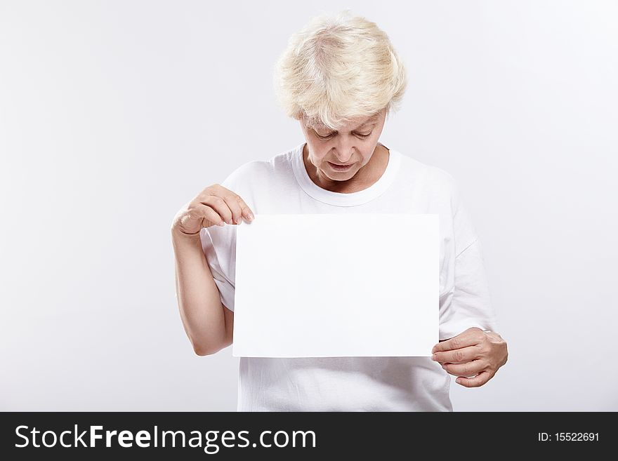 Mature woman looking at a blank form on a white background. Mature woman looking at a blank form on a white background