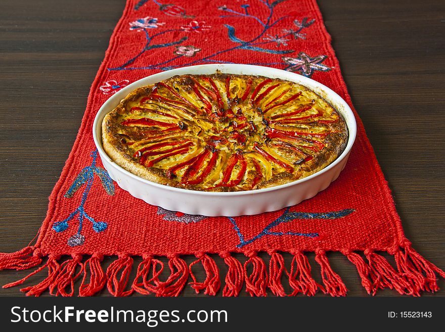 Home-made paprika pie on the red linen and wenge colour table