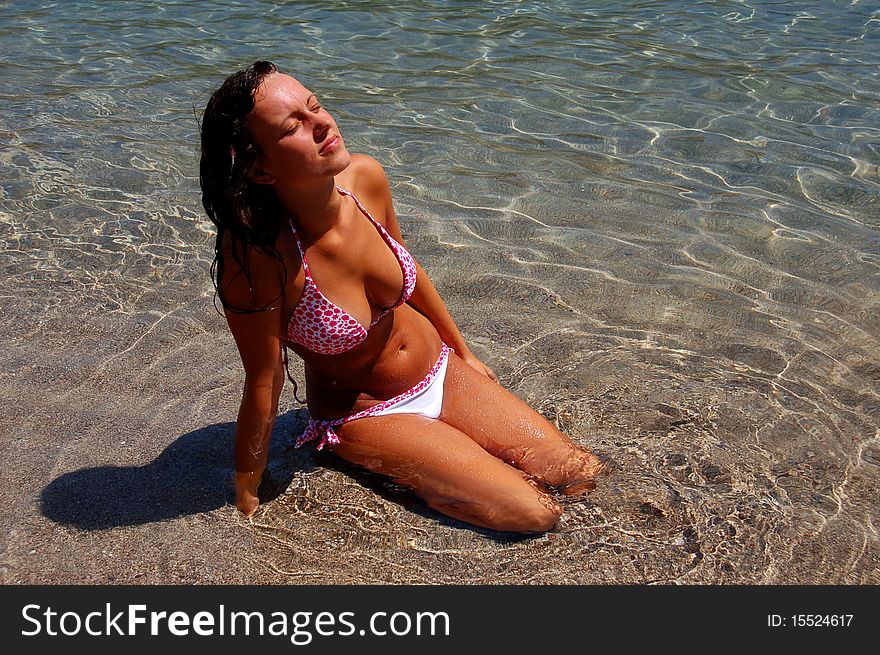 A girl in water on Adriatic sandy beach in Montenegro. A girl in water on Adriatic sandy beach in Montenegro