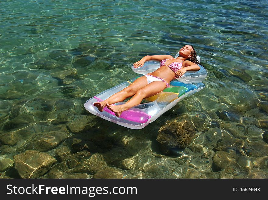 A girl on a mattress in Adriatic waters of Montenegro. A girl on a mattress in Adriatic waters of Montenegro